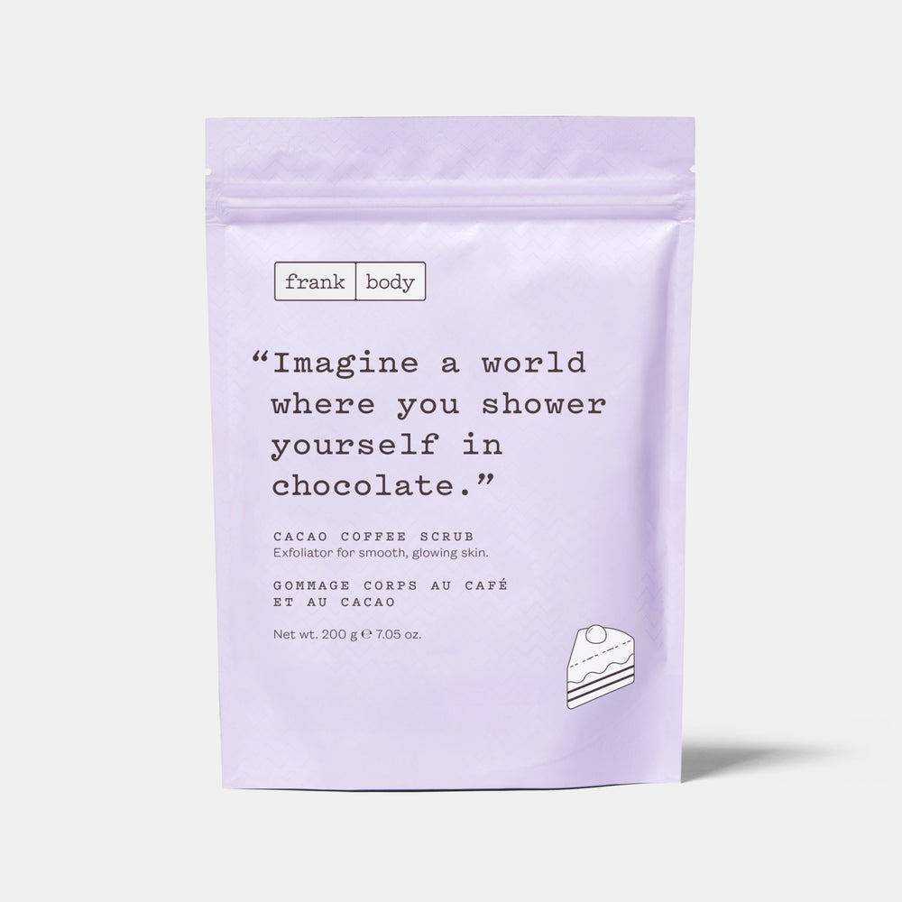 A light lavender stand-up pouch of Frank Body Cacao Coffee Scrub, featuring a quote on the front and a small cake illustration, set against a light gray background.