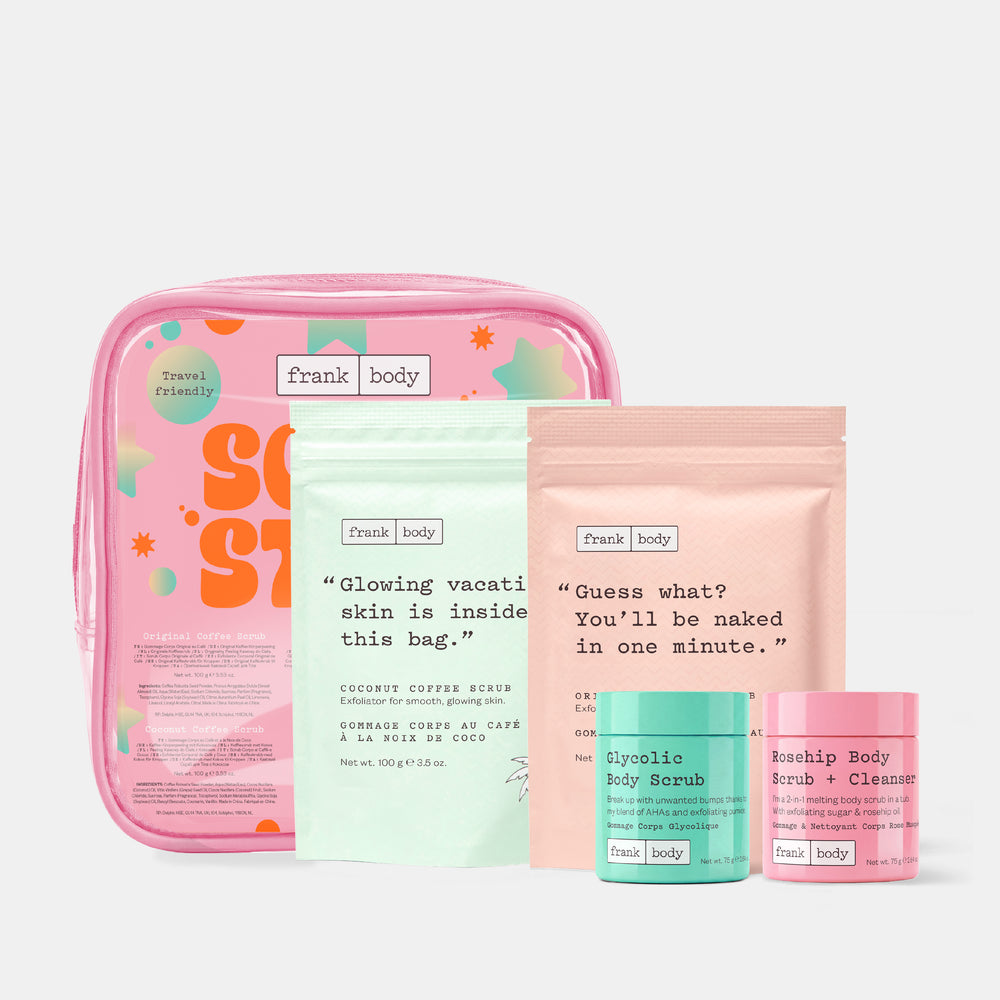 The frank body Scrub Stars Kit laid out with a clear pink travel bag, the Coconut Coffee Scrub and Original Coffee Scrub pouches and the Glycolic and Rosehip scrub tubs.