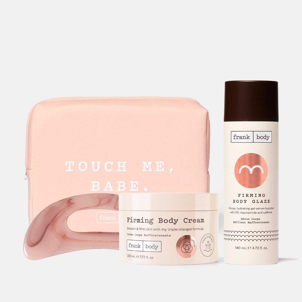 A Frank Body gift set featuring a light pink zippered pouch with 'TOUCH ME, BABE.' printed on it, a pink Body Sculpt Tool, a white jar of Firming Body Cream, and a white bottle of Firming Body Glaze on a light gray background.